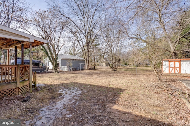 view of yard with a wooden deck and a storage unit