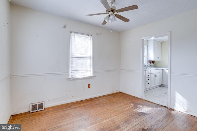 empty room featuring ceiling fan and light hardwood / wood-style floors