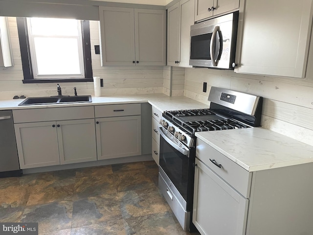 kitchen featuring stainless steel appliances, sink, and gray cabinets