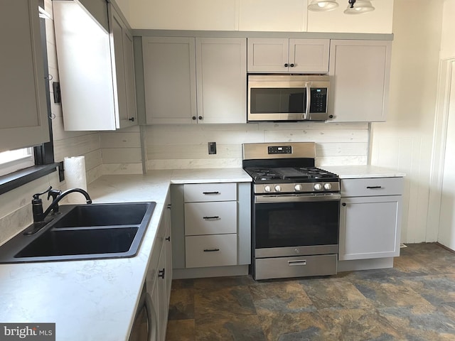 kitchen featuring stainless steel appliances, tasteful backsplash, sink, and gray cabinets