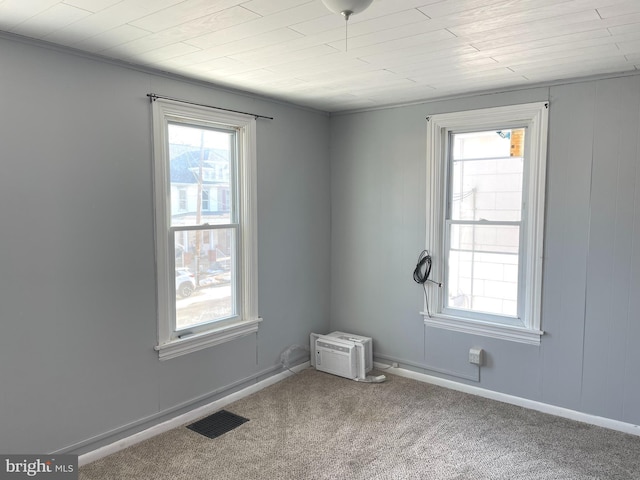 carpeted empty room featuring a wall unit AC