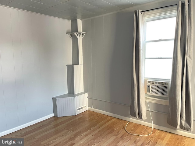 interior space featuring hardwood / wood-style flooring, crown molding, and cooling unit