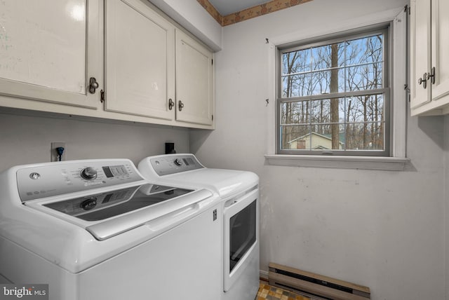 laundry room featuring a baseboard heating unit, washer and clothes dryer, and cabinet space