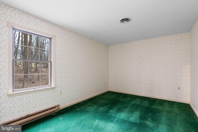 spare room featuring visible vents, dark carpet, baseboard heating, baseboards, and wallpapered walls