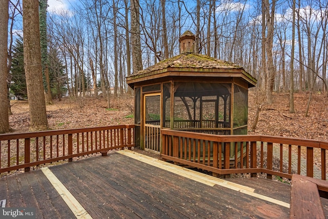 deck featuring a sunroom and a gazebo