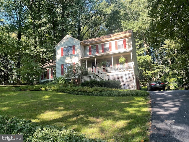 view of front of home featuring aphalt driveway, stairs, a front lawn, and a porch