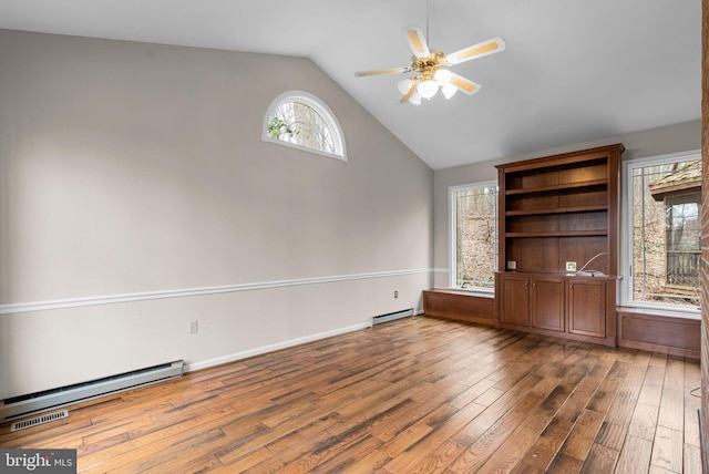 empty room featuring ceiling fan, a baseboard radiator, vaulted ceiling, and wood finished floors