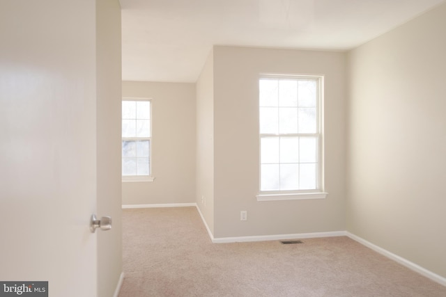 unfurnished room featuring light carpet