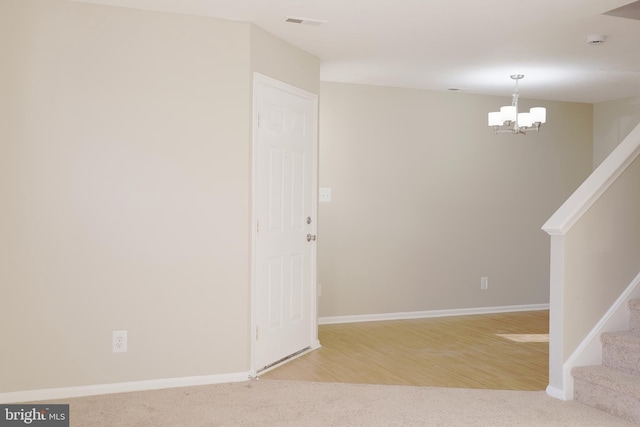 empty room with an inviting chandelier and carpet floors