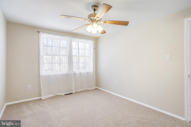 carpeted spare room with ceiling fan