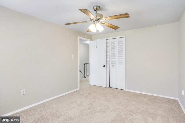 unfurnished bedroom with light colored carpet, ceiling fan, and a closet