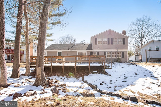 snow covered property with a wooden deck