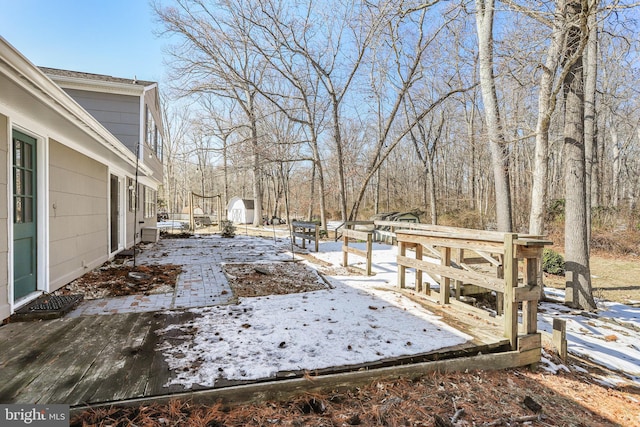 snowy yard featuring a storage shed