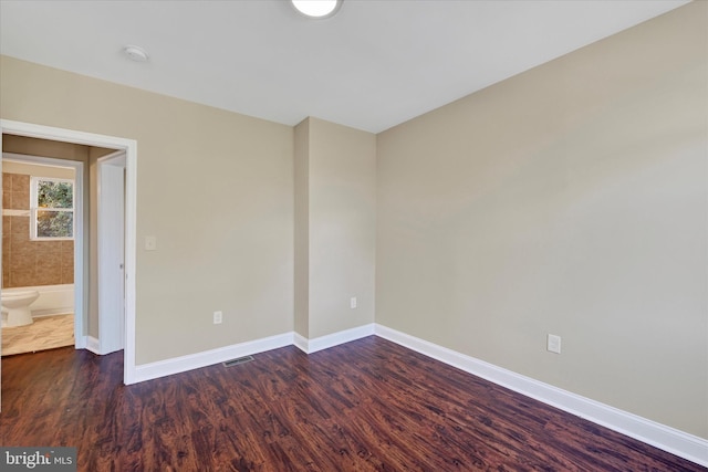 unfurnished room with dark wood-type flooring