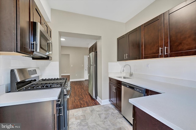 kitchen featuring appliances with stainless steel finishes, sink, backsplash, and dark brown cabinets