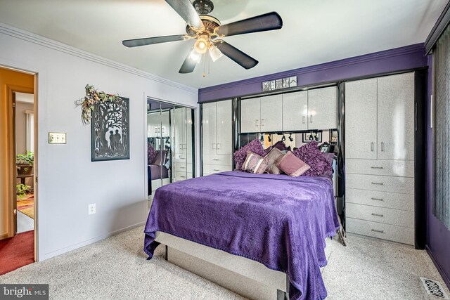 bedroom featuring crown molding, a closet, baseboards, light colored carpet, and a ceiling fan