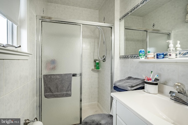 bathroom with a shower stall and vanity