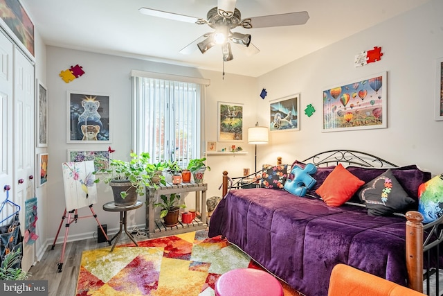 bedroom featuring ceiling fan, wood finished floors, and a closet