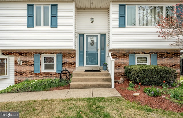 entrance to property featuring brick siding