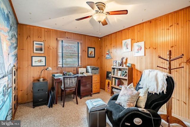 office area featuring wood walls, a ceiling fan, and carpet flooring