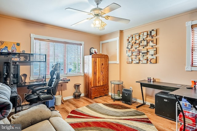 office featuring baseboards, a ceiling fan, wood finished floors, and a healthy amount of sunlight