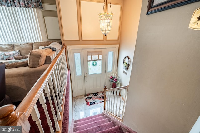 foyer featuring an inviting chandelier and stairs