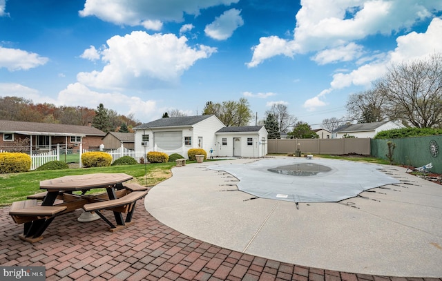 exterior space featuring an outdoor structure, a fenced backyard, a patio area, and a fenced in pool
