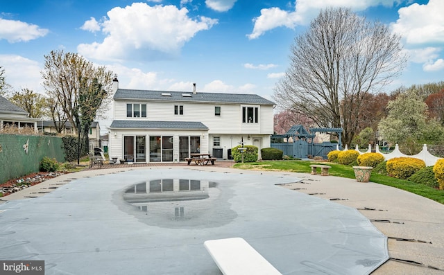 rear view of property featuring a patio, a sunroom, fence, and a chimney