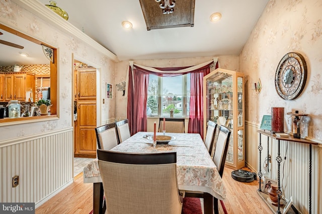 dining area featuring light wood finished floors and wallpapered walls