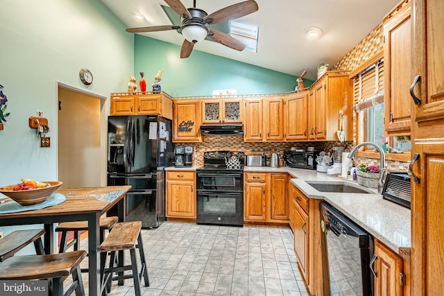 kitchen with tasteful backsplash, a sink, high vaulted ceiling, black appliances, and under cabinet range hood