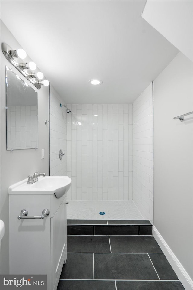 bathroom featuring tiled shower, tile patterned floors, and vanity