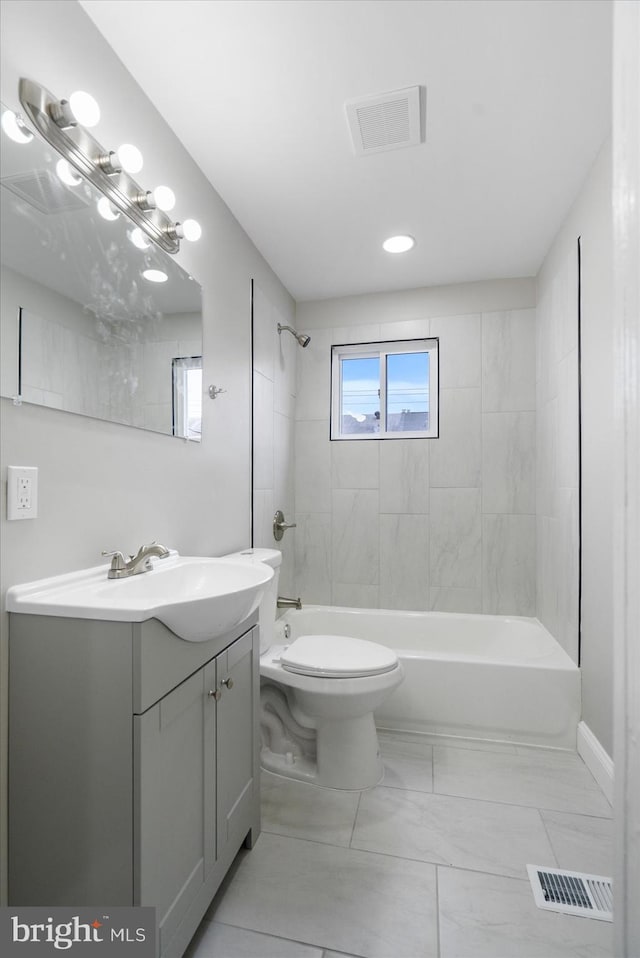 full bathroom featuring vanity, tiled shower / bath, and toilet