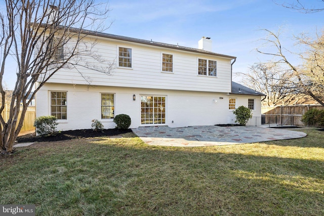 back of house with a patio and a lawn