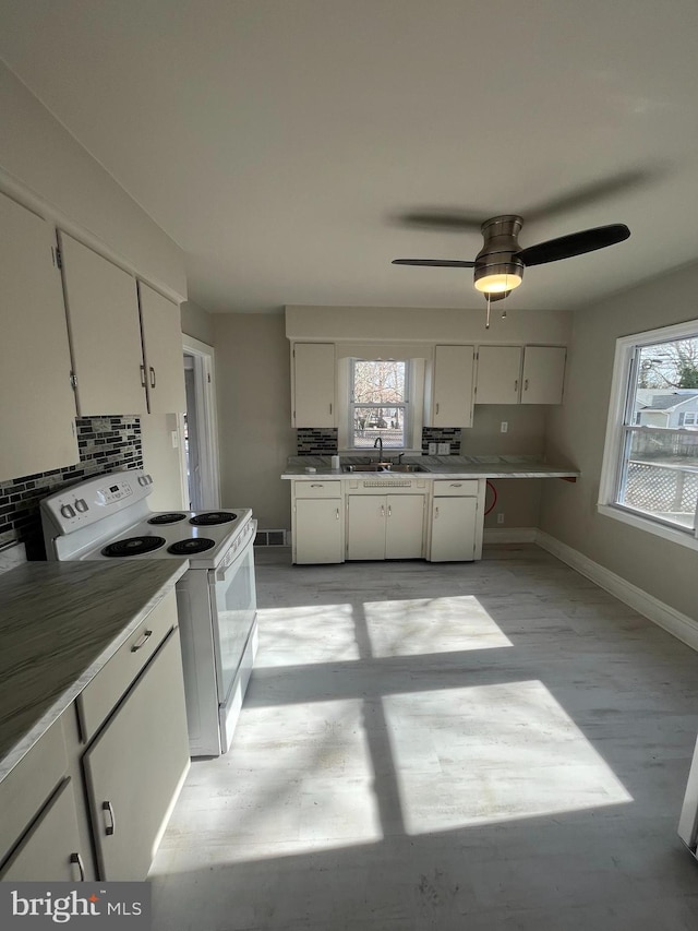 kitchen featuring sink, backsplash, white cabinets, and white appliances