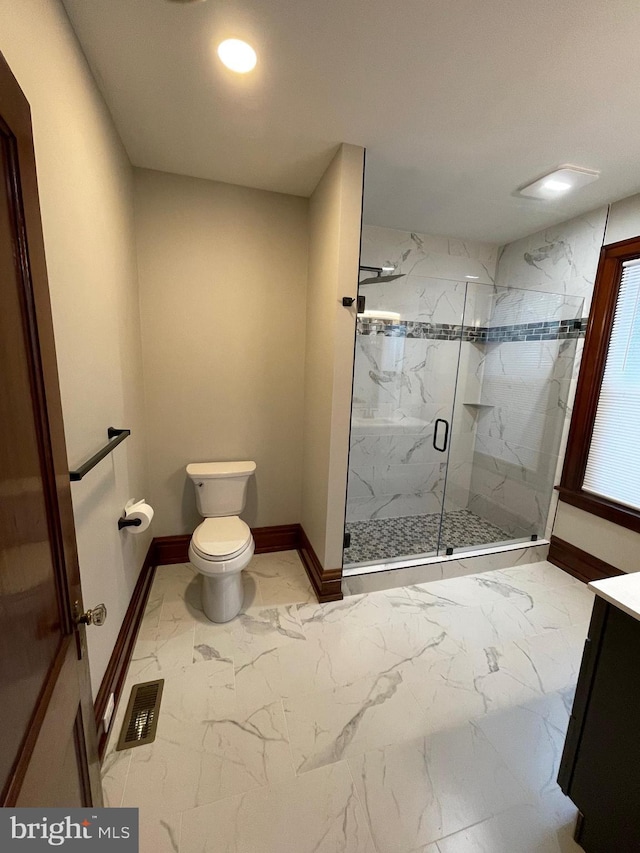 bathroom featuring vanity, an enclosed shower, and toilet