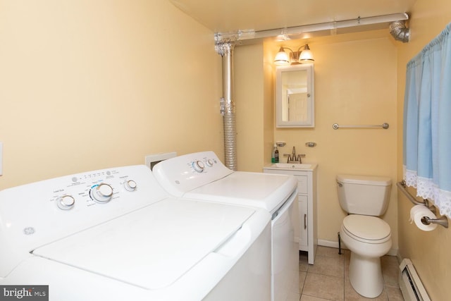 clothes washing area with a baseboard radiator, separate washer and dryer, sink, and light tile patterned floors