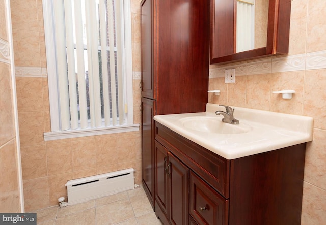 bathroom featuring vanity, tile patterned floors, tile walls, and baseboard heating