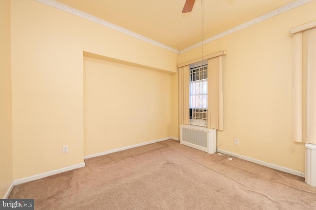 empty room with ceiling fan, ornamental molding, radiator heating unit, and carpet flooring