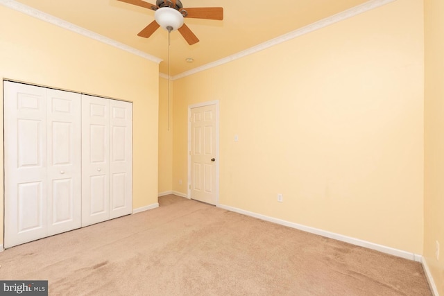 unfurnished bedroom featuring ceiling fan, ornamental molding, carpet floors, and a closet