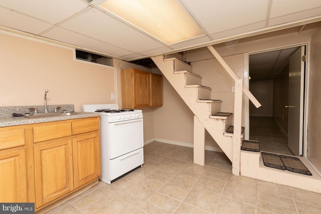 interior space featuring light tile patterned flooring, sink, and a drop ceiling