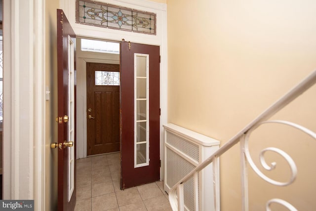 foyer entrance featuring radiator heating unit and light tile patterned floors