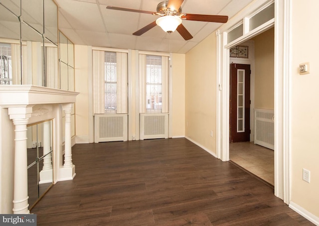 unfurnished living room featuring radiator, dark wood-type flooring, and ceiling fan