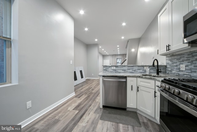 kitchen with white cabinetry, sink, and stainless steel appliances