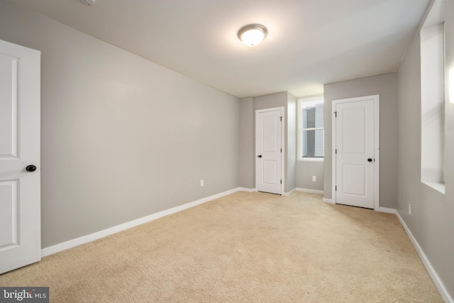 unfurnished bedroom featuring light carpet