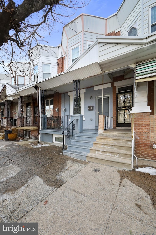 townhome / multi-family property featuring covered porch