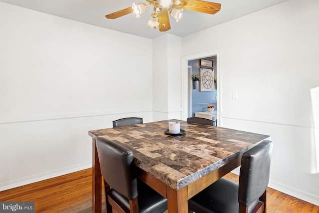 dining area with wood-type flooring and ceiling fan