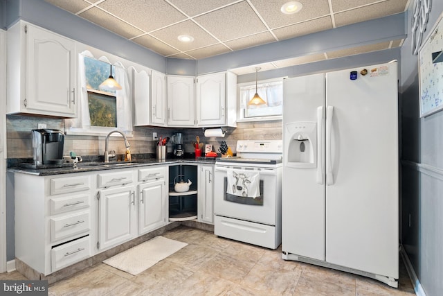 kitchen featuring sink, tasteful backsplash, white cabinets, white appliances, and a drop ceiling