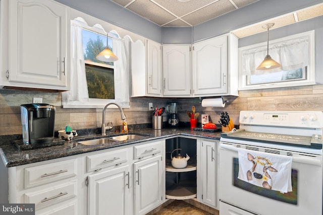 kitchen featuring electric stove, sink, white cabinetry, and pendant lighting