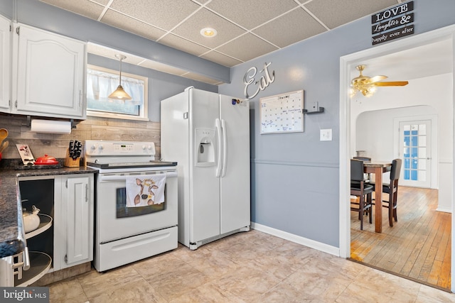 kitchen with decorative light fixtures, white cabinets, decorative backsplash, a drop ceiling, and white appliances