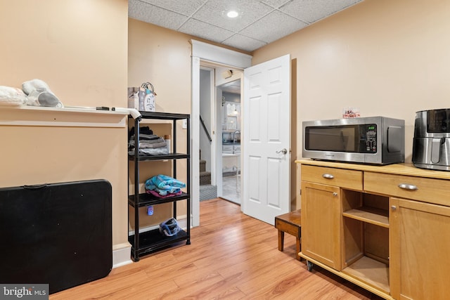 kitchen with light hardwood / wood-style floors and a drop ceiling